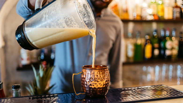 Barman pouring a blended cocktail