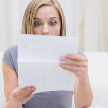 Shocked-woman-reading-letter-in-living-room_web