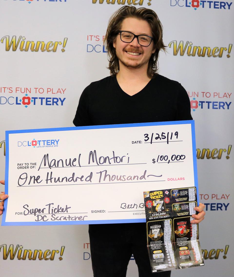 Manuel Montori holds a ceremonial check for the $100,000 prize he claimed from the DC Lottery in March 2019. Montori and two of his former classmates from Princeton University have won several other big lottery prizes in Indiana, the District of Columbia and Missouri.