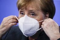 German Chancellor Angela Merkel puts on a face mask after a news conference on further coronavirus measures, at the Chancellery in Berlin, Germany, Tuesday Jan. 19, 2021. (Hannibal Hanschke/Pool via AP)