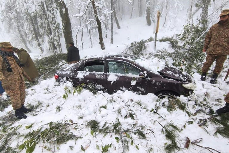 Soldiers clear snow from a trapped car near Murree in this handout photograph released by Pakistan's Inter Services Public Relations (AFP/-)
