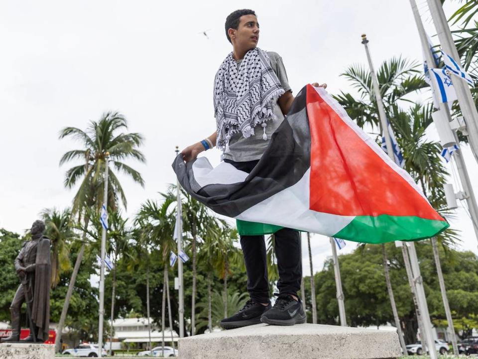 FILE - An activists holds a flag during a pro-Palestine rally near the Torch of Friendship on Friday, Oct. 13, 2023, in downtown Miami, Fla.