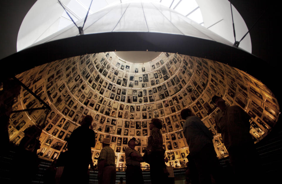 FILE - Visitors look at pictures of Jews killed in the Holocaust in the Hall of Names in the Yad Vashem Holocaust Memorial in Jerusalem, Sunday, April 7, 2013. The annual Israeli memorial day for the 6 million Jews killed in the Holocaust of World War II begins at sundown Sunday. (AP Photo/Sebastian Scheiner, File)