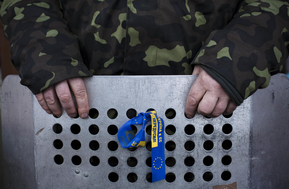 A member of the Right Sector, a Ukrainian far-right opposition group, holds a shield as he stands guard outside a building which is occupied by the movement near Kiev's Independence Square, Ukraine, Sunday, March 9, 2014. (AP Photo/David Azia)