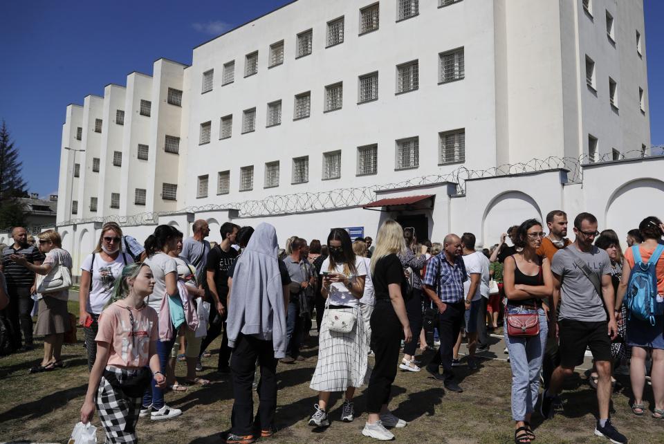 Friends and relatives of those detained during mass rally following presidential election gather at a detention center in Minsk, Belarus, Tuesday, Aug. 11, 2020. The Belarusian Interior Ministry said Tuesday that more than 2,000 people were detained across the country for taking part in unsanctioned protests on Monday evening and overnight. It added that 21 police officers were injured in clashes with protesters, and five of them were hospitalized. (AP Photo/Sergei Grits)