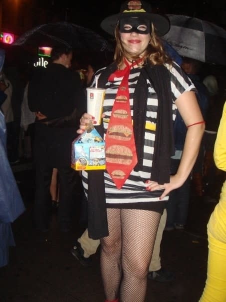 A woman dressed as the Hamburglar while holding McDonald's