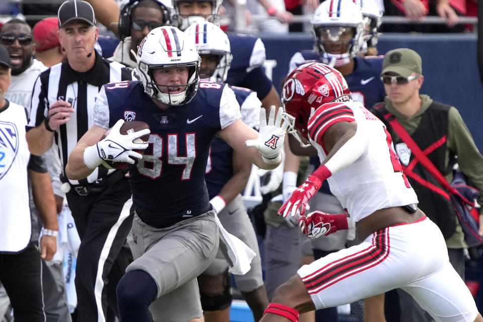 Arizona tight end Tanner McLachlan (84) stiff arms Utah cornerback JaTravis Broughton during an NCAA college football game, Saturday, Nov. 18, 2023, in Tucson, Ariz. (AP Photo/Rick Scuteri)