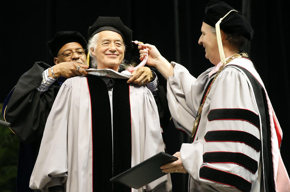 Former Led Zeppelin guitarist Jimmy Page, center, receives an honorary degree of Doctor of Music from Berklee College of Music President Roger Brown, right, and Provost Lawrence Simpson during the school's commencement in Boston, Saturday, May 10. 2014. (AP Photo/Winslow Townson)