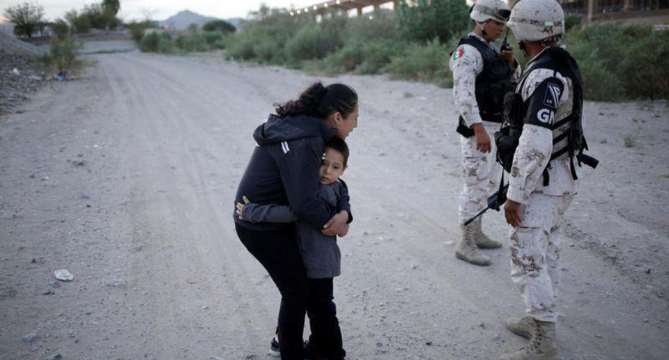 The mother embracing her son while guards stood nearby at the Mexican border into the United States.