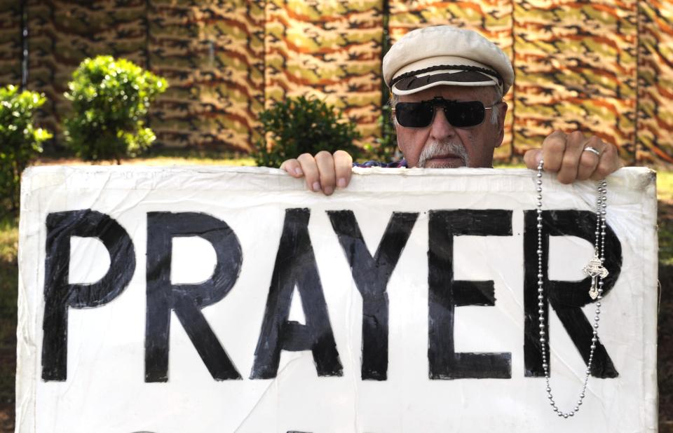 Major Fecteau, a Huntsville anti-abortion protester, holds a rosary and prays while he holds a sign on the sidewalk in front of the Alabama Women's Wellness Center Friday, May 17, 2019 in Huntsville, Ala. The Alabama legislation signed into law Wednesday would make performing or attempting to perform an abortion at any stage of pregnancy a felony. The ban does not allow exceptions for rape and incest.(AP Photo/Eric Schultz)