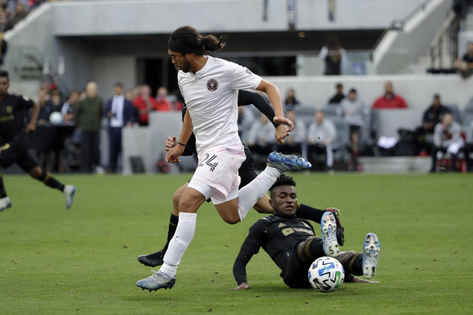 Los Angeles FC's Latif Blessing, bottom, makes a slide tackle on Inter Miami CF's Lee Nguyen during the second half of an MLS soccer match Sunday, March 1, 2020, in Los Angeles. (AP Photo/Marcio Jose Sanchez)