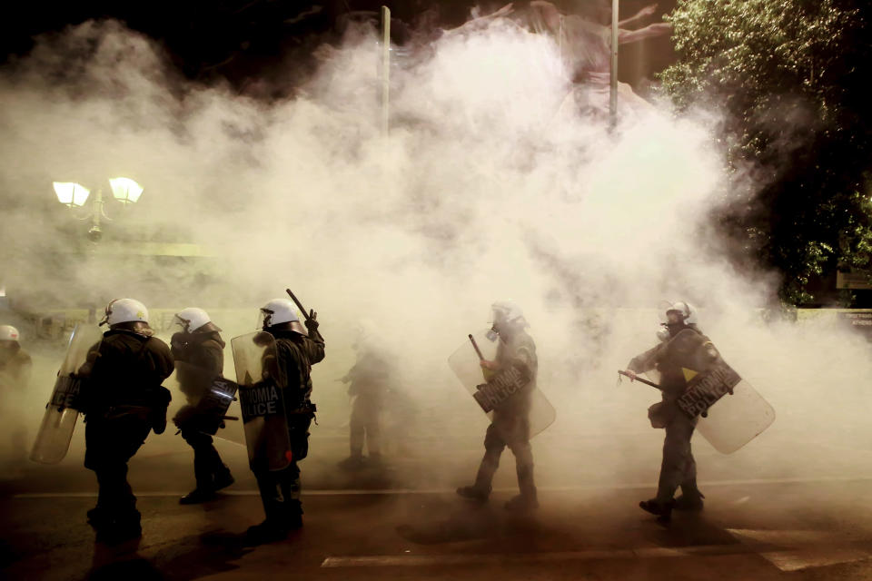 Riot police officers walk as smoke from tear gas during clashes with protestors against the visit of German Chancellor Angela Merkel in Athens, Thursday Jan. 10, 2019. Greek riot police used tear gas against a small group of left-wing activists protesting the visit of German Chancellor Angela Merkel to Athens. (InTime News via AP)