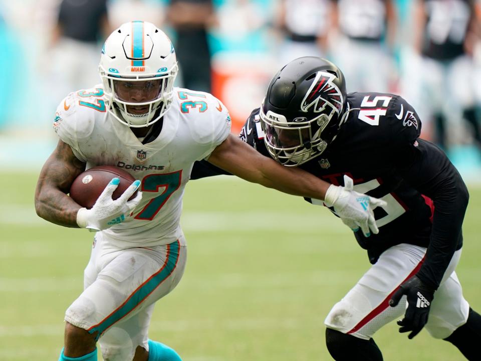 Myles Gaskin fights off a defender against the Atlanta Falcons.