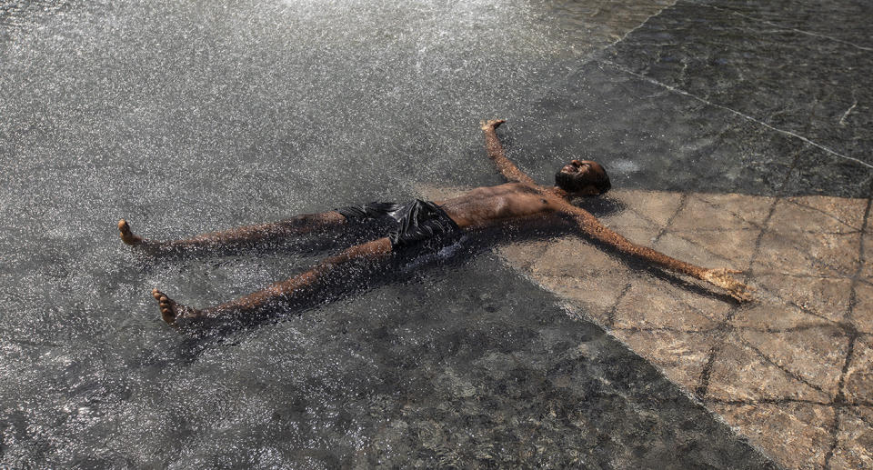 A man cools down in a water feature.