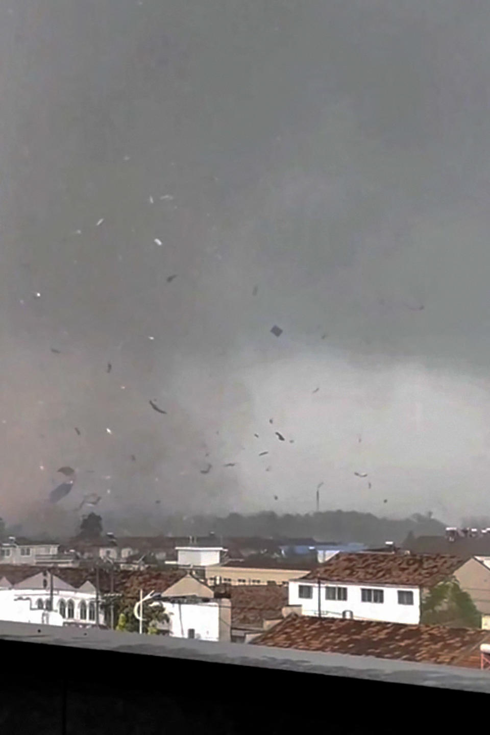 In this frame taken from a video, debris scatters in the sky after a tornado swept through houses in Suqian city in eastern China's Jiangsu Province on Tuesday, Sept. 19, 2023. Two tornadoes within hours killed and injured several people in eastern China, state media said Wednesday. (Zhang via AP)