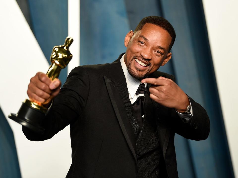 Will Smith holds his Oscar and smiles