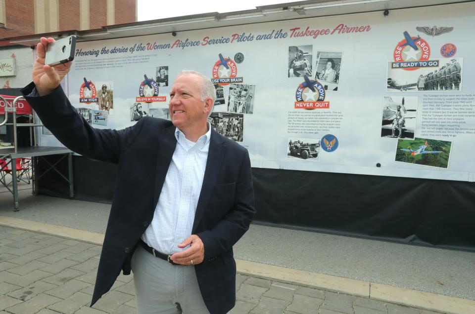 Akron Mayor Dan Horrigan takes a selfie photo for his social media Wednesday after viewing The Rise Above Traveling Exhibit featuring Women Air Force Service Pilots and Tuskegee Airmen in front of Canal Park.