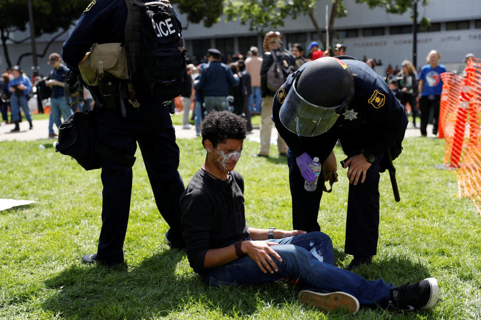 A demonstrator is being tend to by police after he was pepper-sprayed during a rally for and against U.S. President Donald Trump in Berkeley, California in Berkeley, California, U.S., April 15, 2017. REUTERS/Stephen Lam