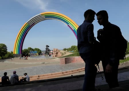 People gather near the Soviet monument, "Arch of the Friendship of Nations", which is painted with rainbow colours, in celebration of diversity ahead of the Eurovision Song Contest, in central Kiev, Ukraine May 4, 2017. REUTERS/Gleb Garanich