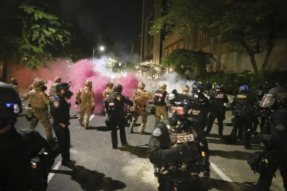 Police respond to protesters during a demonstration, Friday, July 17, 2020 in Portland, Ore. Militarized federal agents deployed by the president to Portland, fired tear gas against protesters again overnight as the city’s mayor demanded that the agents be removed and as the state’s attorney general vowed to seek a restraining order against them. (Dave Killen/The Oregonian via AP)