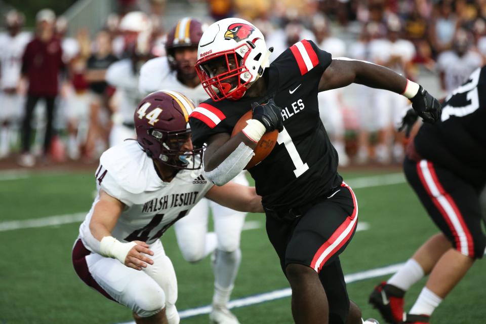 St. Charles’ Fred Nimely (1) rushes by Cuyahoga Falls Walsh Jesuit’s Kasey Kish (44) on Sept. 17.