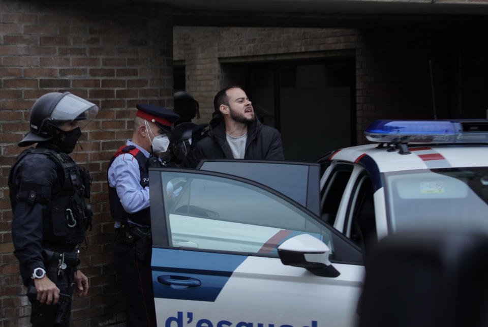 Rap singer Pablo Hasél is detained by police officers at the University of Lleida, Spain, Tuesday, Feb. 16, 2021. A rapper in Spain and dozens of his supporters have locked themselves inside a university building in the artist's latest attempt to avoid a prison sentence for insulting the monarchy and praising terrorism. (AP Photo/Joan Mateu)