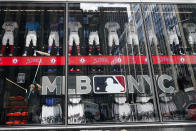 A worker cleans the front window of the MLB Flagship store Wednesday, Sept. 30, 2020, in New York. Inside a former Manhattan television studio, the scaffolding has come down and Major League Baseball’s first retail store opens Friday across from Radio City Music Hall in a part of Midtown Manhattan largely emptied by the coronavirus pandemic. (AP Photo/Frank Franklin II)