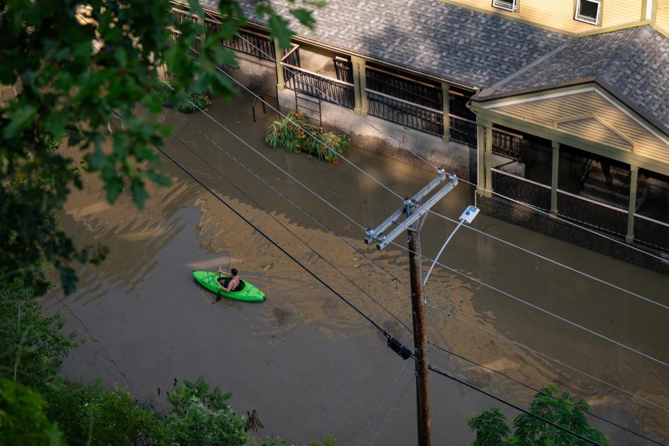 In an aerial view, a kayaker paddles through the flooded waters of Elm Street (Getty Images)