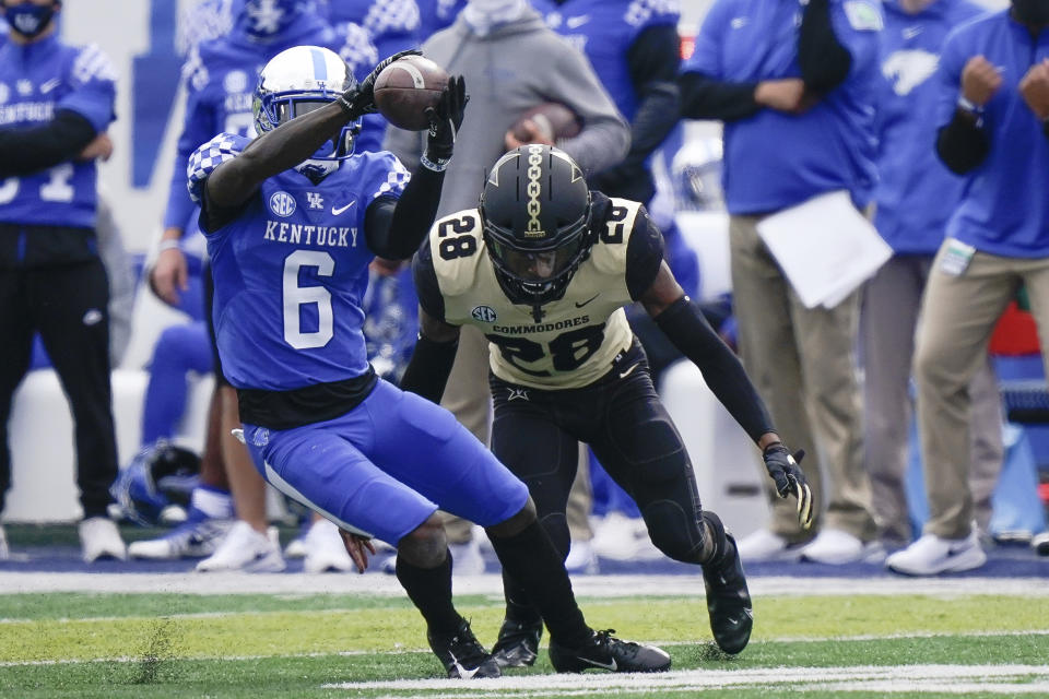 Kentucky wide receiver Josh Ali (6) catches the ball as he is tackled by Vanderbilt cornerback Allan George (28) during the first half of an NCAA college football game, Saturday, Nov. 14, 2020, in Lexington, Ky. (AP Photo/Bryan Woolston)