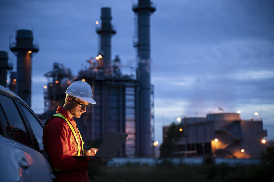 Petrochemical engineers work slowly and heavily with smart tablets in the oil and gas industry at night.