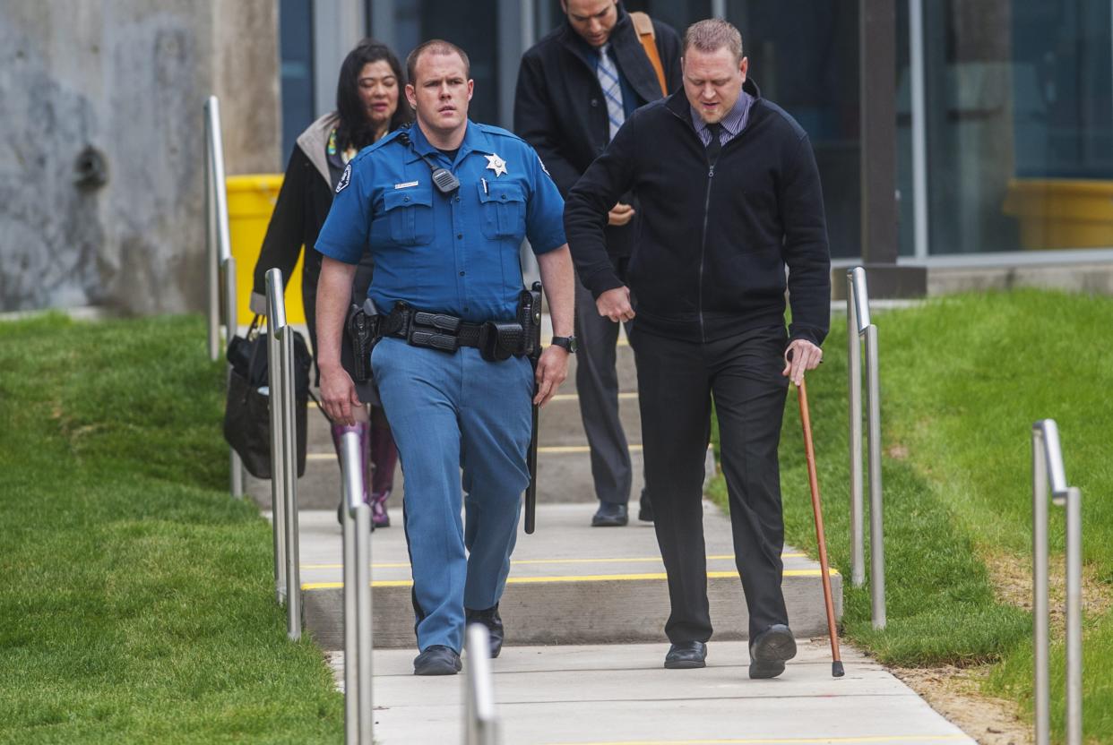 A deputy escorts theater shooting victim Josh Nowlan from the courthouse on Monday. Nearly $140,000 in grant money is being used for victims' security.(Reuters/Evan Semon)