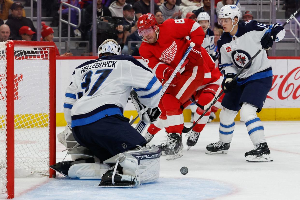 Winnipeg Jets goaltender Connor Hellebuyck (37) makes the save on Detroit Red Wings right wing Daniel Sprong (88) in the second period at Little Caesars Arena in Detroit on Thursday, Oct. 26, 2023.