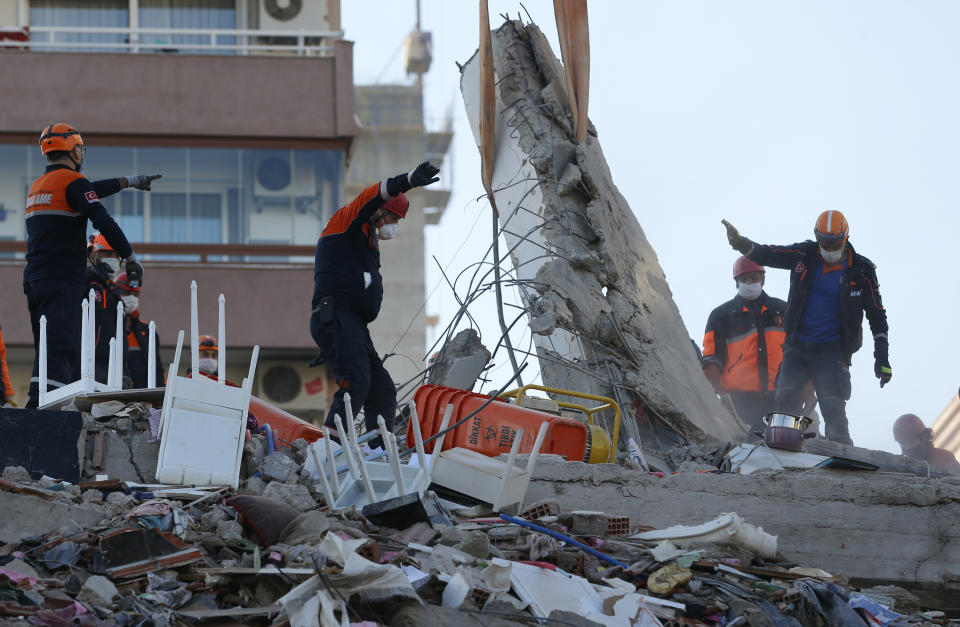 Members of rescue services search for survivors in the debris of a collapsed building in Izmir, Turkey, Saturday, Oct. 31, 2020. Rescue teams on Saturday ploughed through concrete blocs and debris of eight collapsed buildings in Turkey's third largest city in search of survivors of a powerful earthquake that struck Turkey's Aegean coast and north of the Greek island of Samos, killing dozens Hundreds of others were injured. (AP Photo/Darko Bandic)