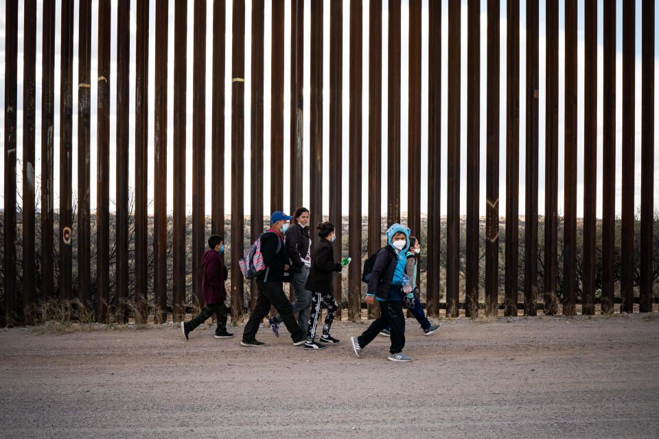 A group of migrant families from Central America walk along side the border wall between the U.S. and Mexico after crossing in to the U.S. near the city of Sasabe, Arizona, Sunday, January 23, 2022. / Credit: Salwan Georges/The Washington Post via Getty Images