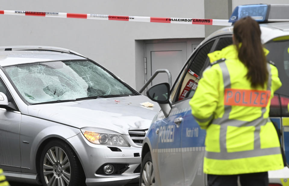 Police stand next to the scene of the accident with the car that is said to have crashed into a carnival parade in Volkmarsen, central Germany, Monday, Feb. 24, 2020. Several people have been injured, according to the police. The driver had been arrested by the police. (Uwe Zucchi/dpa via AP)