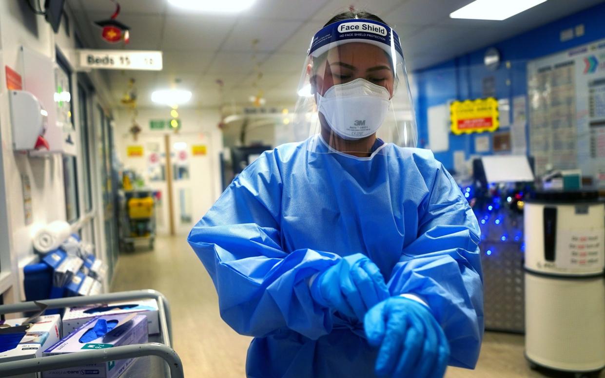 A nurse donning full PPE on a ward for Covid patients at King's College Hospital in 2021