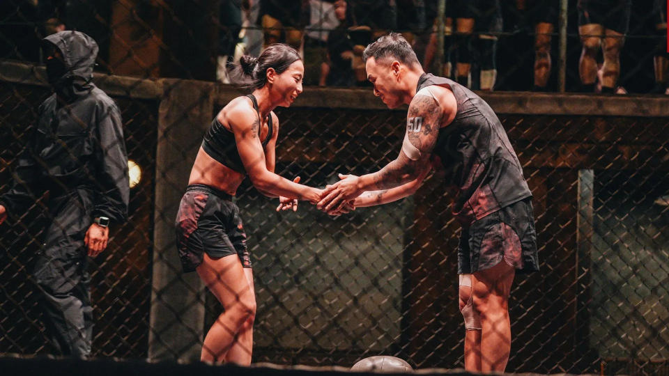 sim yu-ri and hunter lee shake hands while standing in an octagon, with a referee to their left, in 'physical 100' season 2