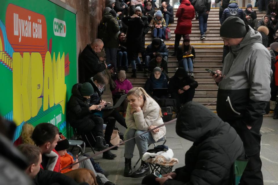 People gather in the subway station being used as a bomb shelter during a rocket attack in Kyiv, Ukraine, Thursday, Jan. 26, 2023.