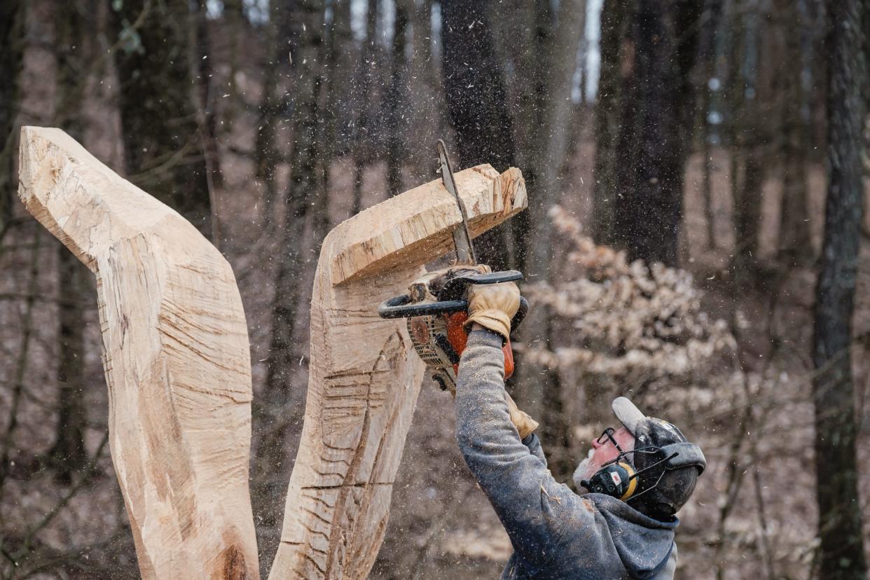 Dan Kidd, of Conotton Creek Woodworks, carves a giant attacking eagle with a chainsaw in Sherrodsville. The sculpture was commissioned by a private resident.