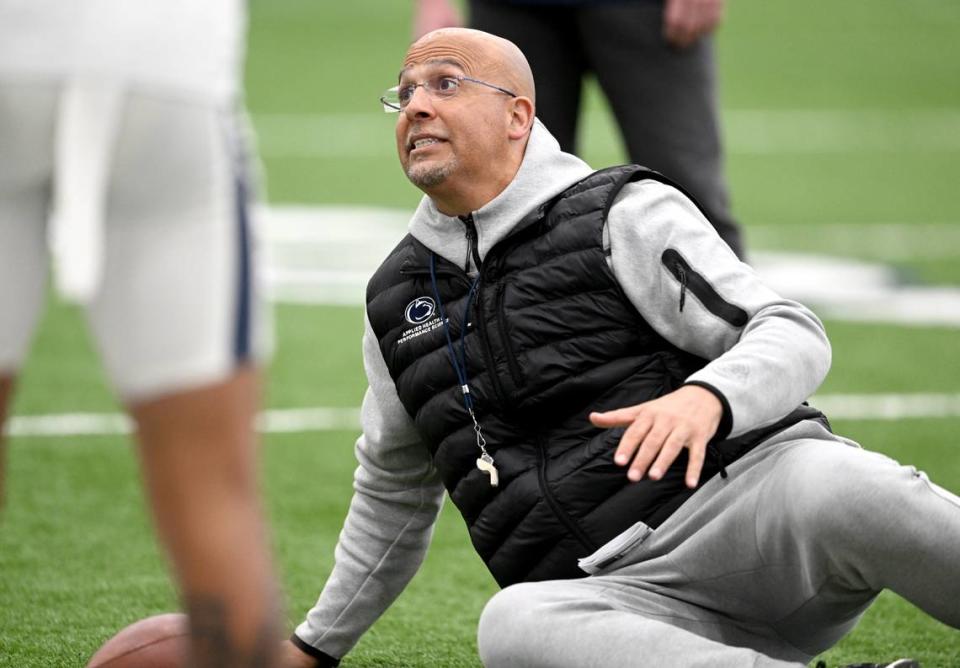 Penn State football coach James Franklin demonstrates a technique to a group of defensive players during spring practice on Tuesday, March 14, 2023.