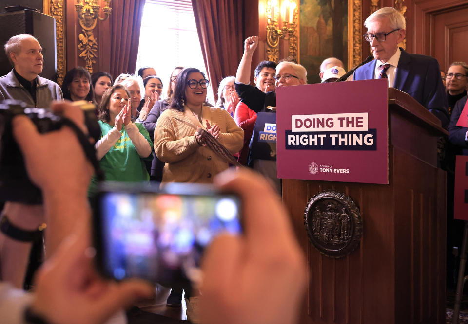 Supporters of Wisconsin Gov. Tony Evers' plan to re-draw the state's legislative maps react as he stands at a podium during the bill-signing event at the Wisconsin State Capitol in Madison, Wis. Monday, Feb. 19, 2024. Democrats tried unsuccessfully for more than a decade to overturn the Republican-drawn maps. But it wasn’t until control of the state Supreme Court flipped in August after the election of liberal Justice Janet Protasiewicz that Democrats found a winning formula. (John Hart/Wisconsin State Journal via AP)