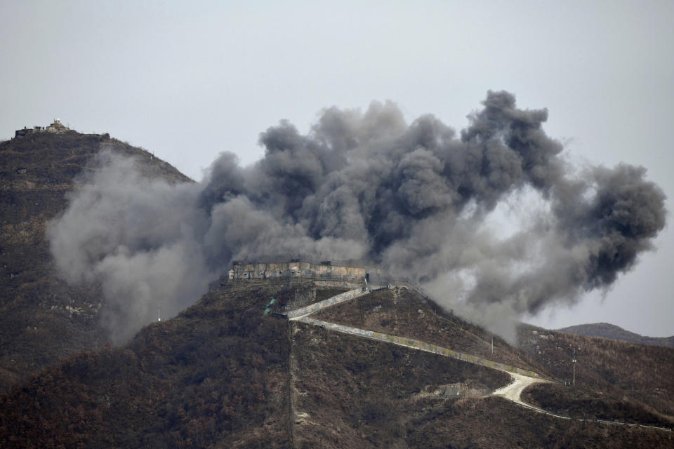 FILE - In this Nov. 15, 2018, file photo, smoke from an explosion rises as part of the dismantling of a South Korean guard post in the Demilitarized Zone dividing the two Koreas in Cheorwon, South Korea, as a North Korean guard post sits high in the upper left. On both sides of the world's most heavily armed border Thursday, June 25, 2020, solemn ceremonies will mark the 70th anniversary of the outbreak of a war that killed and injured millions, left large parts of the Korean Peninsula in rubble and technically still continues. (Jung Yeon-je/Pool Photo via AP, File)