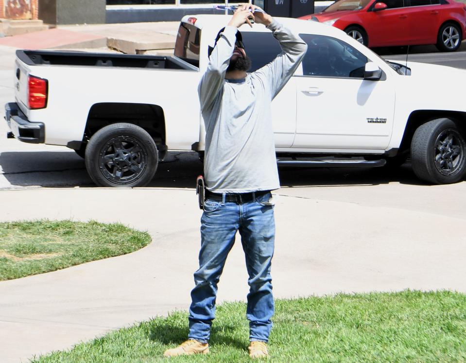 A citizen takes a picture of the eclipse with his phone at Park Central in downtown Wichita Falls on Monday, April 8, 2024.