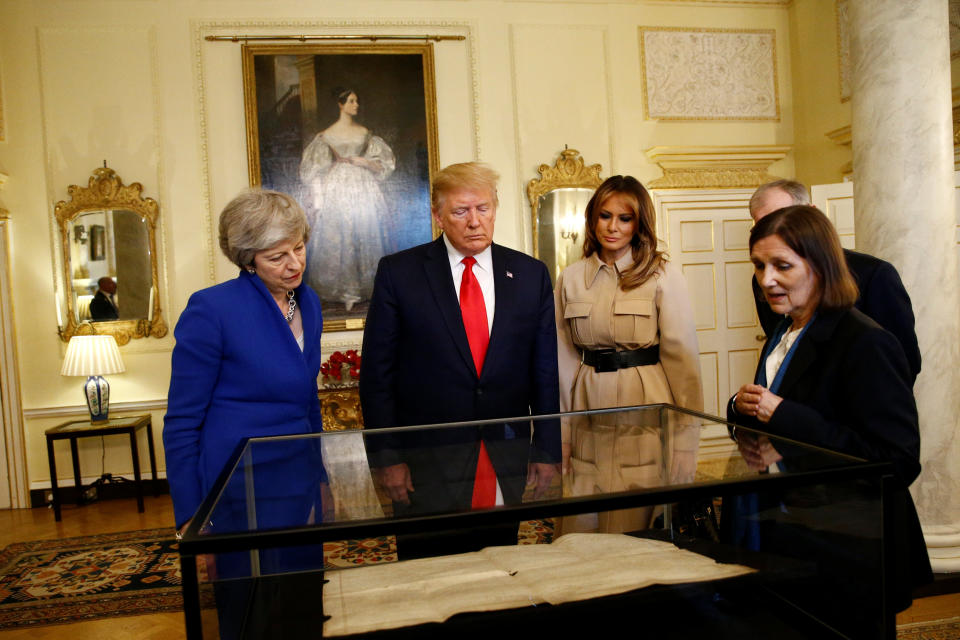 Prime Minister Theresa May (left) with US President Donald Trump and first lady Melania Trump view a historical document in Downing Street, London, on the second day of his state visit to the UK.