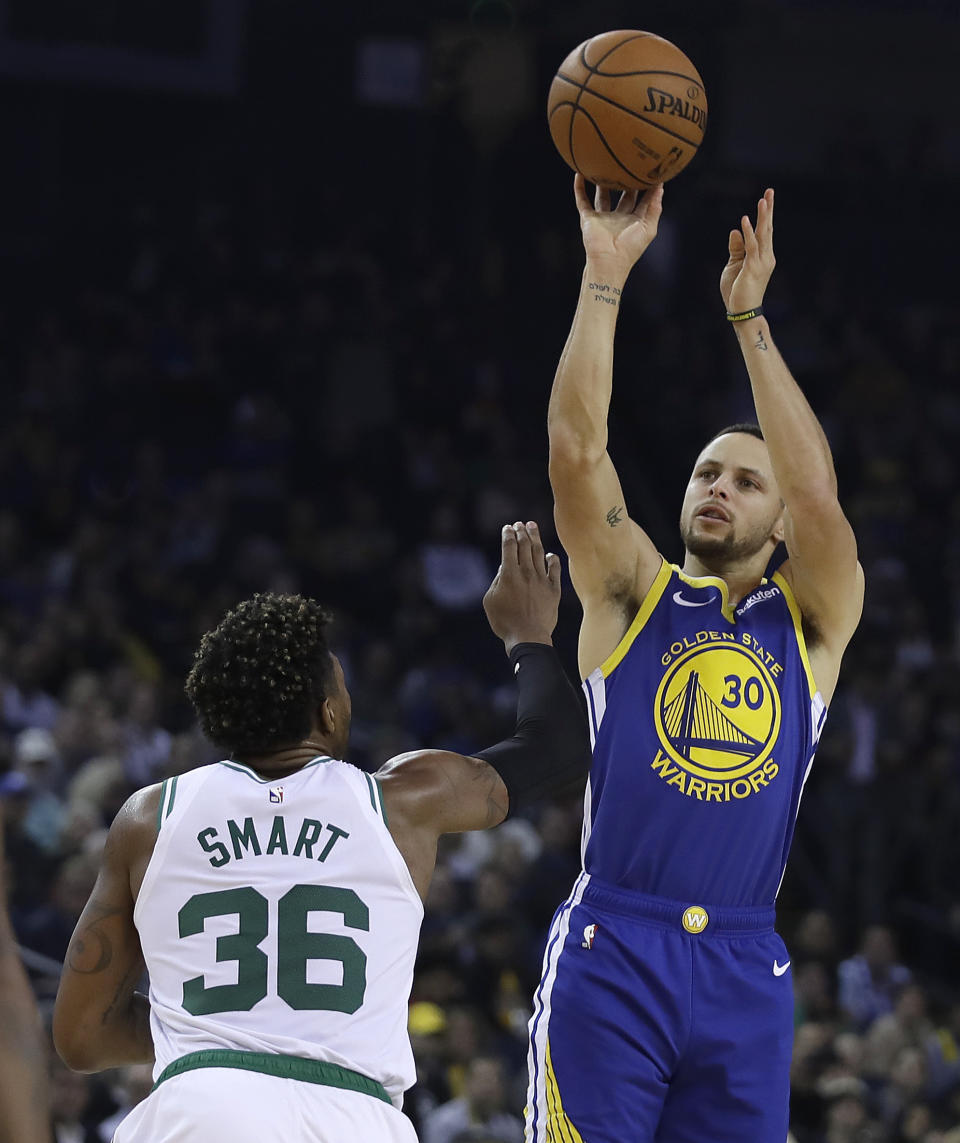 Golden State Warriors' Stephen Curry shoots over Boston Celtics' Marcus Smart (36) during the first half of an NBA basketball game Tuesday, March 5, 2019, in Oakland, Calif. (AP Photo/Ben Margot)