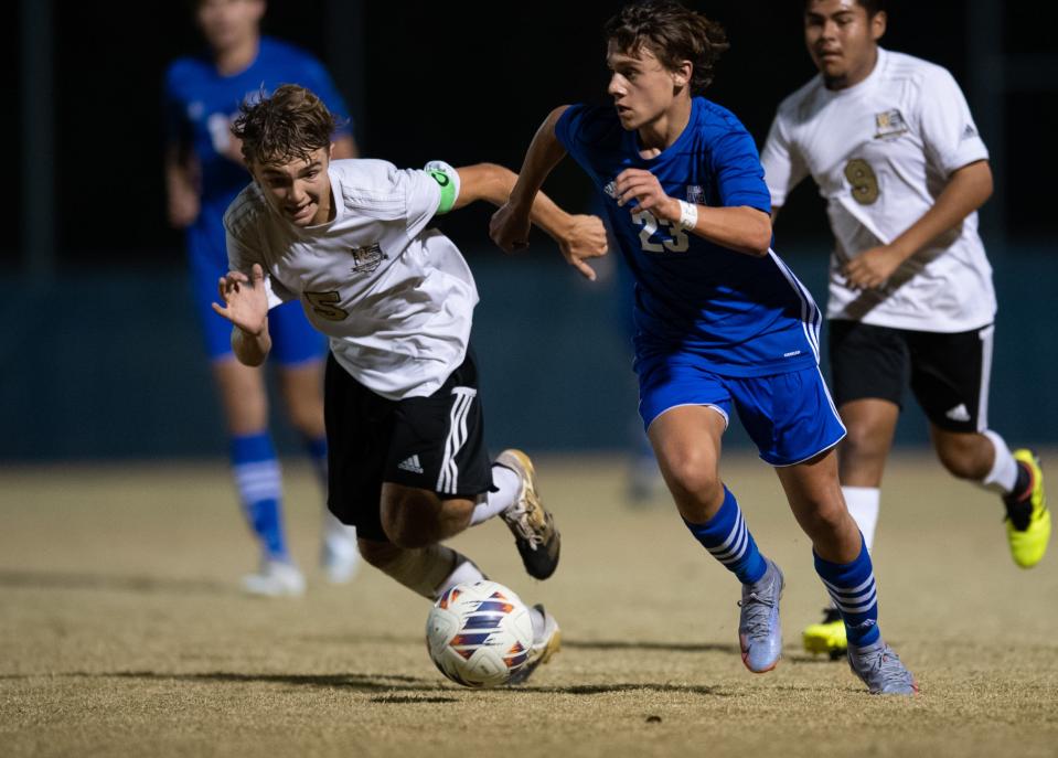 Memorial’s Cohen Havill (23) runs the ball down the field as he’s defended by Washington’s Ethan Christen (5) during the Memorial Tigers vs Washington Hatchets game at Memorial High School in Evansville, Ind., Wednesday evening, Oct. 12, 2022. 