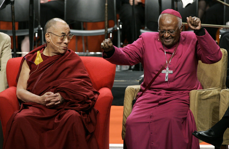 FILE - The Dalai Lama, left, looks on as Archbishop Desmond Tutu, of South Africa, does an impromptu dance move after remarking that his wireless microphone made him feel like pop star Michael Jackson, during an event Tuesday, April 15, 2008 at the University of Washington in Seattle. When Tutu died Sunday, Dec. 26, 2021 at age 90, he was remembered as a Nobel laureate, a spiritual compass, a champion of the anti-apartheid struggle who turned to other global causes after Nelson Mandela, another moral heavyweight, became South Africa's first Black president. (AP Photo/Ted S. Warren, File)