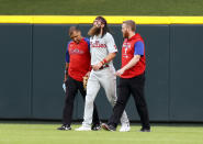 Philadelphia Phillies center fielder Brandon Marsh, center, is helpd off the field during the third inning of the team's baseball game against the Cincinnati Reds in Cincinnati on Tuesday, Aug. 16, 2022. (AP Photo/Paul Vernon)