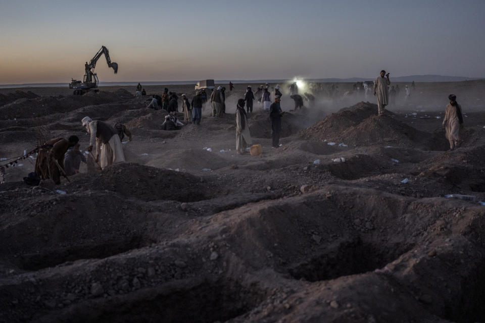 Afghans bury hundreds of people killed in an earthquake to a burial site, outside a village in Zenda Jan district in Herat province, western of Afghanistan, Monday, Oct. 9, 2023. Saturday's deadly earthquake killed and injured thousands when it leveled an untold number of homes in Herat province. (AP Photo/Ebrahim Noroozi)