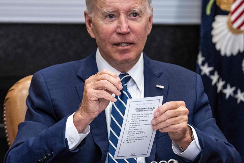 Joe Biden speaks from his notes with governors, labor leaders and private companies launching the Federal-State Offshore Wind Implementation Partnership as he drops by a meeting at the White House in Washington, DC on 23 June (AFP via Getty Images)